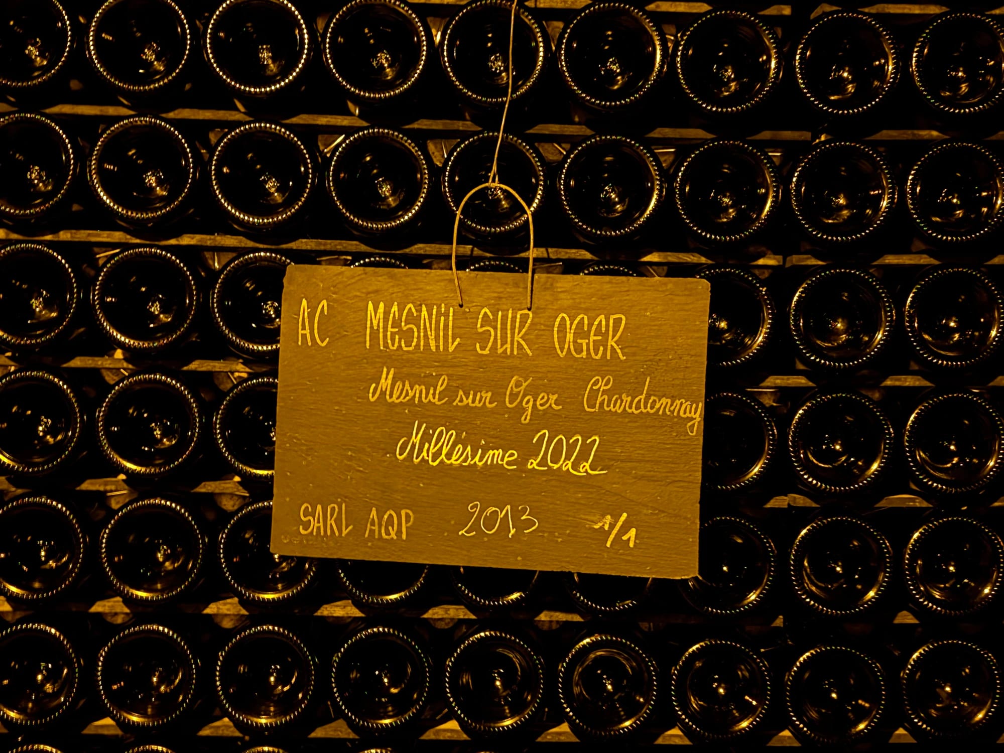 Bottles aging on a riddling rack in a cellar