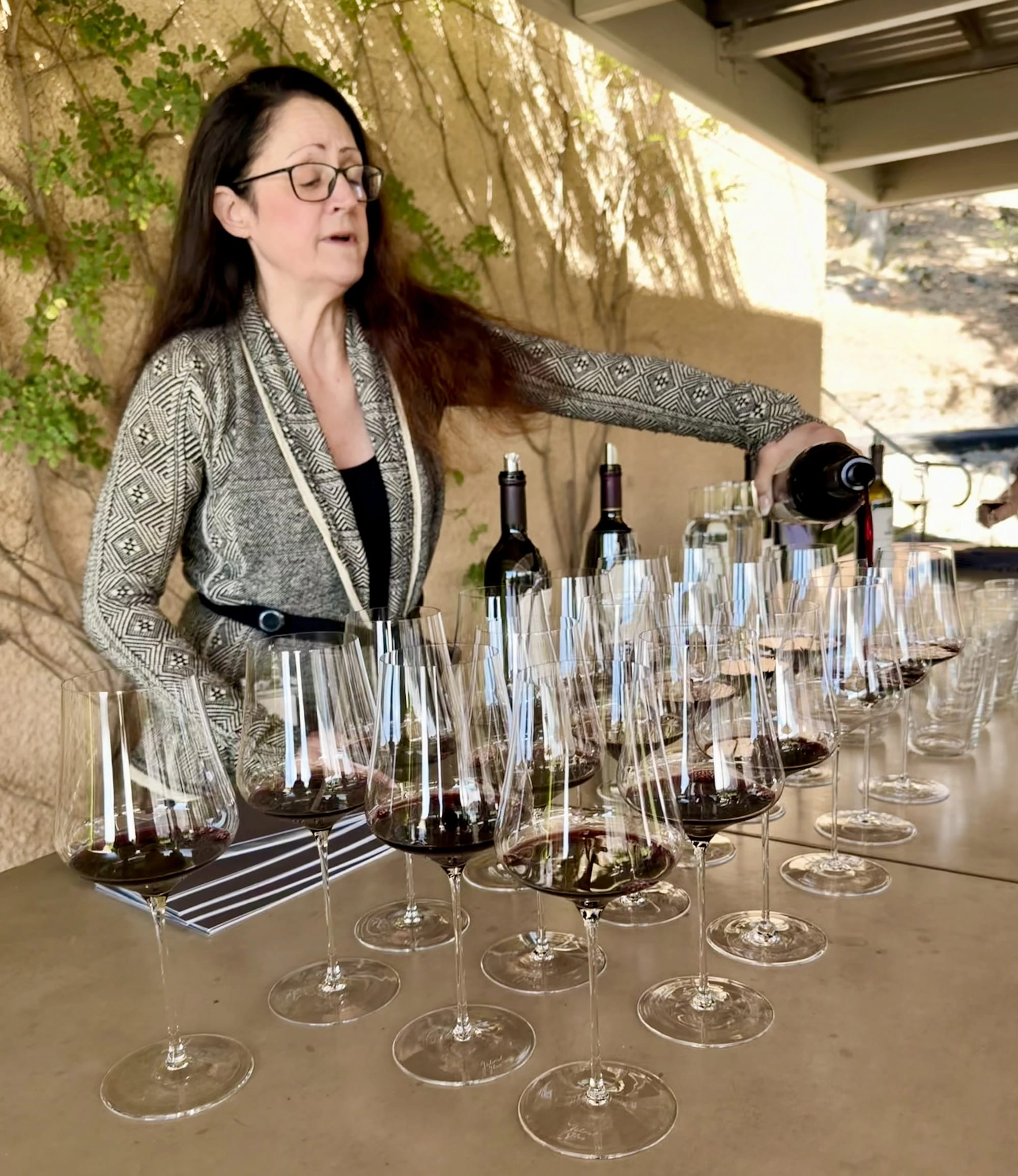 A winemaker pouring a flight for the group